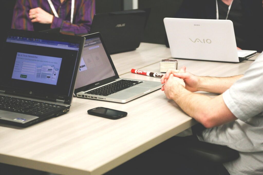 Laptops and a phone on a meeting-room table during a team discussion